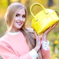 Beautiful girl with a yellow leather bag autumn day in nature Royalty Free Stock Photo