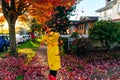 Beautiful girl in the yellow raincoat walking outdoors in autumn. Young woman enjoying autumn weather Royalty Free Stock Photo