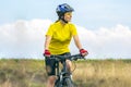 Beautiful girl in yellow riding a bike in nature. Sports and recreation. Hobbies and health