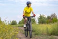 Beautiful girl in yellow riding a bike in nature. Sports and recreation. Hobbies and health