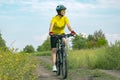 Beautiful girl in yellow riding a bike in nature. Sports and recreation. Hobbies and health