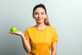 Beautiful girl in yellow t-shirt holding green apple in palm with copy space. idea design Royalty Free Stock Photo