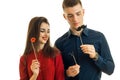 Beautiful girl and a young man holding paper props and photographing