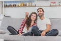 Beautiful girl and a young man sitting on the couch and watch TV. People relax on the couch.Young man in glasses and Royalty Free Stock Photo