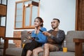 beautiful girl and young man sitting on sofa while watching Royalty Free Stock Photo