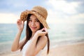 Beautiful girl young woman asia in a  hat smiling on the beach at sunset,enjoy summer vacation on the beach Royalty Free Stock Photo