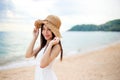 Beautiful girl young woman asia in a  hat smiling on the beach at sunset,enjoy summer vacation on the beach Royalty Free Stock Photo