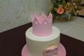 Beautiful girlish birthday cake with pink mastic crown, bow, inscription name Maria. One year old or five years old birthday cake