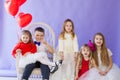 Beautiful girls and boy with red balloons in the shape of a heart Royalty Free Stock Photo