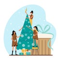 Beautiful girls decorate the Christmas tree on the background of gifts. Royalty Free Stock Photo