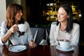Beautiful Girls Drinking Coffee in Cafe. business meeting with Cup of Hot Beverage Royalty Free Stock Photo
