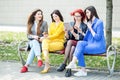 Beautiful girls with gadgets are sitting on the bench. The concept of the Internet, social networks, study and lifestyle Royalty Free Stock Photo