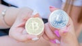 Beautiful girls hands with manicure holding 2 souvenir coins of Bitcoin cryptocurrency. Modern digital crypto gold, e-commerce, Royalty Free Stock Photo