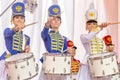 beautiful girls in a hussar uniform play drums at a carnival procession at a flower festival in a city park on a summer day