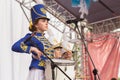 beautiful girls in a hussar uniform play drums at a carnival procession at a flower festival in a city park on a summer day