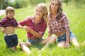Beautiful girls with little boy on the grass Royalty Free Stock Photo