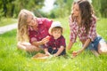 Beautiful girls with little boy on the grass Royalty Free Stock Photo