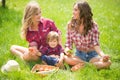 Beautiful girls with little boy on the grass Royalty Free Stock Photo