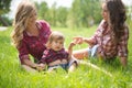 Beautiful girls with little boy on the grass Royalty Free Stock Photo