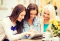 Beautiful girls looking at tablet pc in cafe Royalty Free Stock Photo