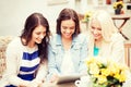 Beautiful girls looking at tablet pc in cafe Royalty Free Stock Photo