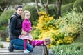 Beautiful girls in pink jackets and colorful skirts with mother on the bridge