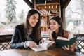 Beautiful girls sitting in wooden gazebo with books Royalty Free Stock Photo