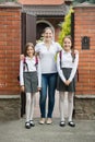 Beautiful girls standing with their mother in doorway before going to school