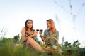 Beautiful girls tasting wine in a field near vineyard field. Celebrating successful harvest season. Couple having a romantic date Royalty Free Stock Photo