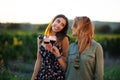 Beautiful girls tasting wine in a field near vineyard field. Celebrating successful harvest season. Couple having a romantic date Royalty Free Stock Photo