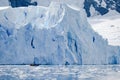Glacier wall in Antarctica, majestic blue and white ice wall with Zodiac in front.