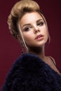 Beautiful glamor blondie woman in fur coat , evening makeup and hairstyle. The beauty of the face.