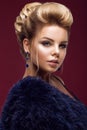 Beautiful glamor blondie woman in fur coat , evening makeup and hairstyle. The beauty of the face.