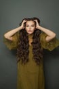 Beautiful glamorous young fashion model woman with long dark wavy hair in green dress posing on black background Royalty Free Stock Photo