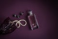 glass on a burgundy background with black stone jewelry, women`s perfumes and pearls Royalty Free Stock Photo