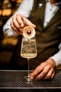 beautiful glass with drink stands on bar counter and bartender& x27;s hand decorates it Royalty Free Stock Photo