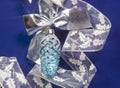 Beautiful glass New Year`s toy of an cone, white brilliant tinsel on a blue background - New Year`s composition, a card Royalty Free Stock Photo