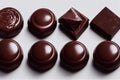 Beautiful glossy sweets made of dark chocolate circles and cubes on white background.