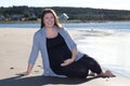 Pregnant woman sits on the beach