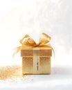 A beautiful black and gold Christmas present on a solid color background - festive glitter and ribbons Royalty Free Stock Photo