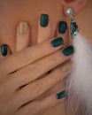 Beautiful gold shimmering, dark green shiny and matte nails. Luxury extravagant white feather earrings.