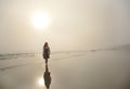 Girl walking on the beach on  foggy morning. Royalty Free Stock Photo