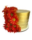 Beautiful golden cake decorated with fresh orange gerberas isolated on a white background