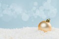 Beautiful golden Christmas balls in the snow on a blue background with bokeh lights. happy new year card Royalty Free Stock Photo