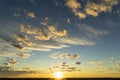 Beautiful Golden clouds illuminated by the rays of the sun at sunset float across the yellow-blue sky Royalty Free Stock Photo