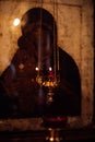 Beautiful golden figured censer thurible with burning candle hanging with chain in front of old icon of Divine Mother. Royalty Free Stock Photo