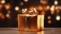 Beautiful golden gift box on light table against blurred festive lights