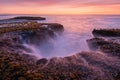 A beautiful golden late evening seascape with misty waves and dramatic rock formations