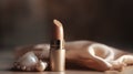 Beautiful golden lipstick and pearls on wooden table, closeup