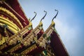 Beautiful golden naga sculptures on the church gable roof at the public Buddhist temple in Thailand. Royalty Free Stock Photo